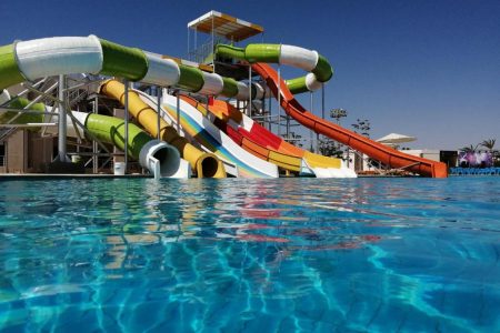 Family enjoying water slides and sea access at New Eagles Aqua Park Hurghada with pools, zoo area, and summer activities.