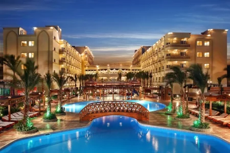 Families enjoying water slides and swimming pools at AMC Royal Aqua Park Hurghada with snacks and relaxing resort atmosphere.