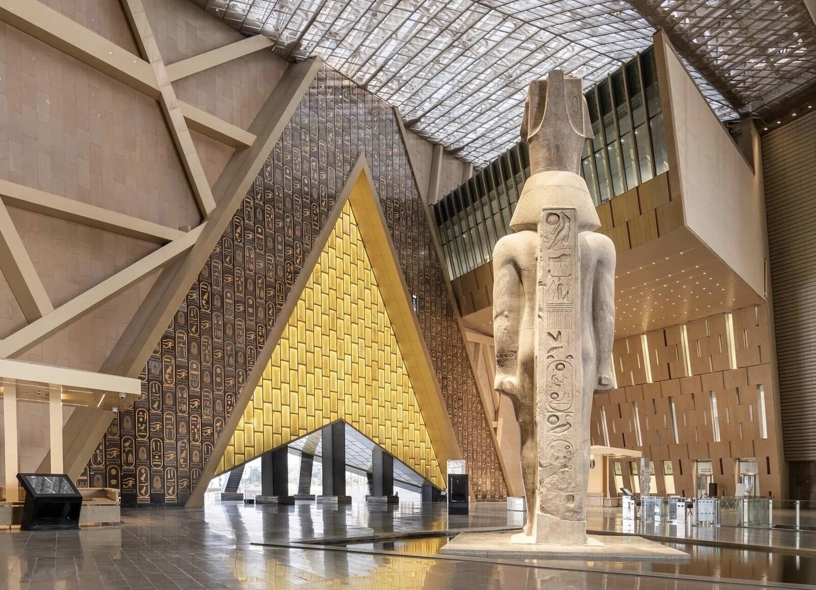 the Grand Egyptian Museum exterior showcasing ancient Egyptian statues near the Giza Pyramids