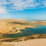 Fayoum Oasis landscape with Lake Qarun, desert dunes, and lush farmland in Egypt