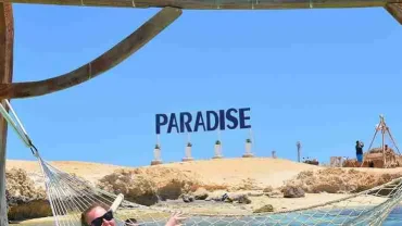 Tourists enjoying an island excursion from Hurghada with a Red Sea boat trip, beach activities, and a foam party.
