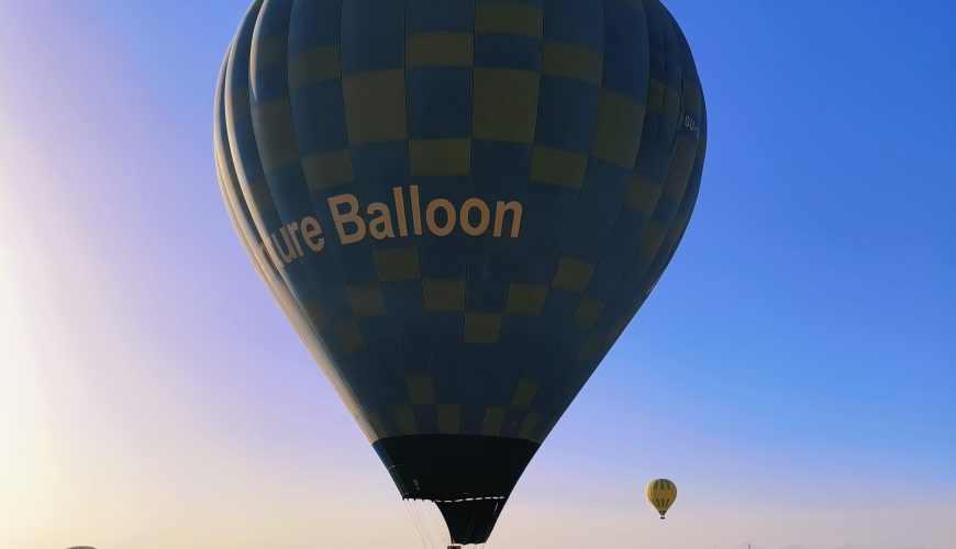 Heißluftballons steigen bei Sonnenaufgang über die historische Landschaft von Luxor am Westufer des Nils auf.