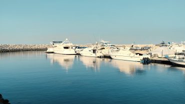 Yachts moored at Hurghada Marina in Egypt, surrounded by waterfront restaurants and a scenic Red Sea promenade.