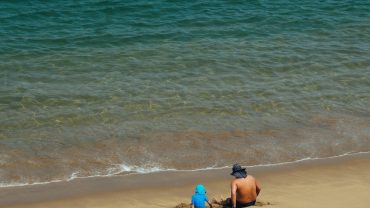 Urlauber genießen einen entspannten Strandtag in Hurghada mit türkisblauem Wasser und einem sonnigen Sandstrand am Roten Meer.